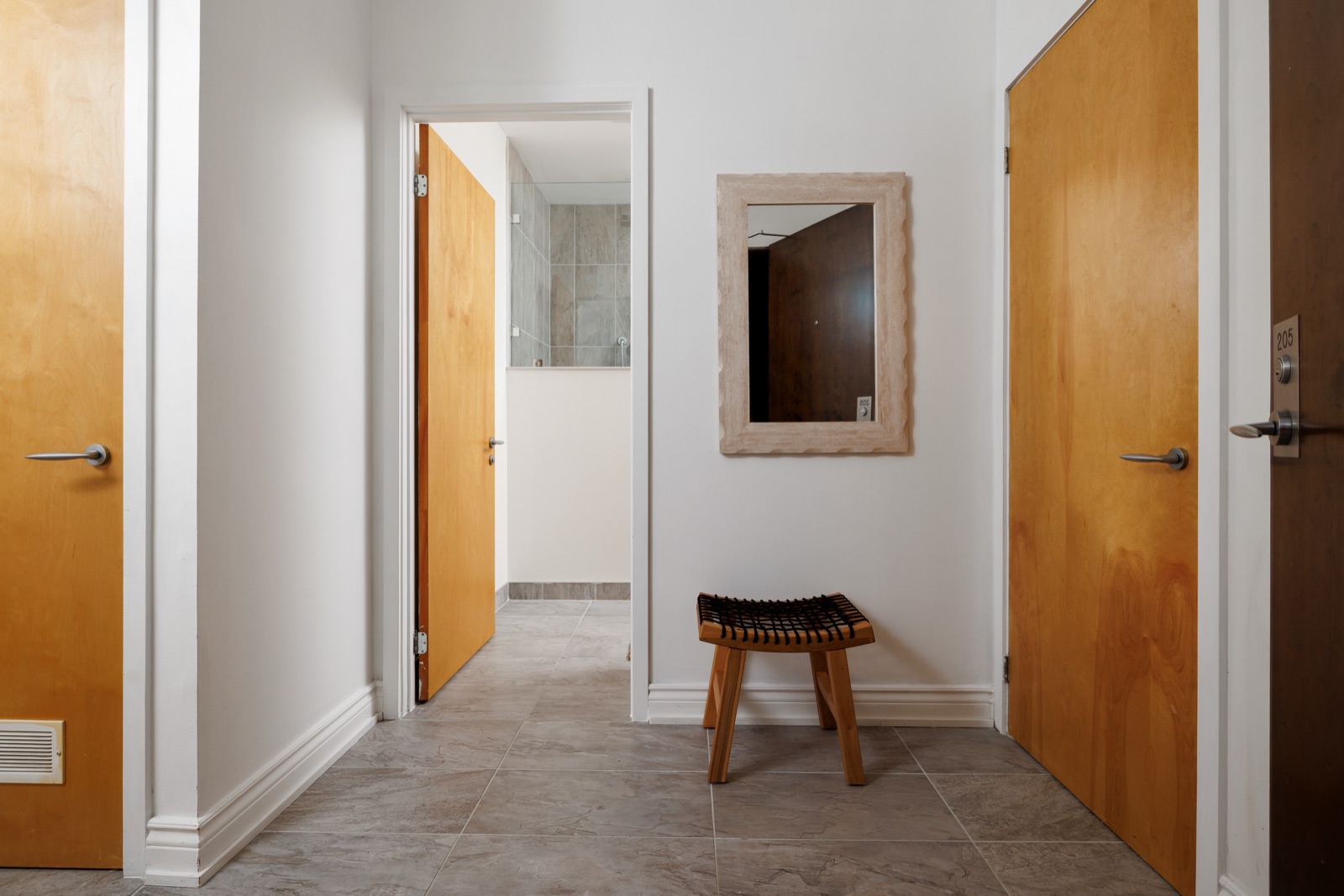 Entry hall with birch doors and a woven stool