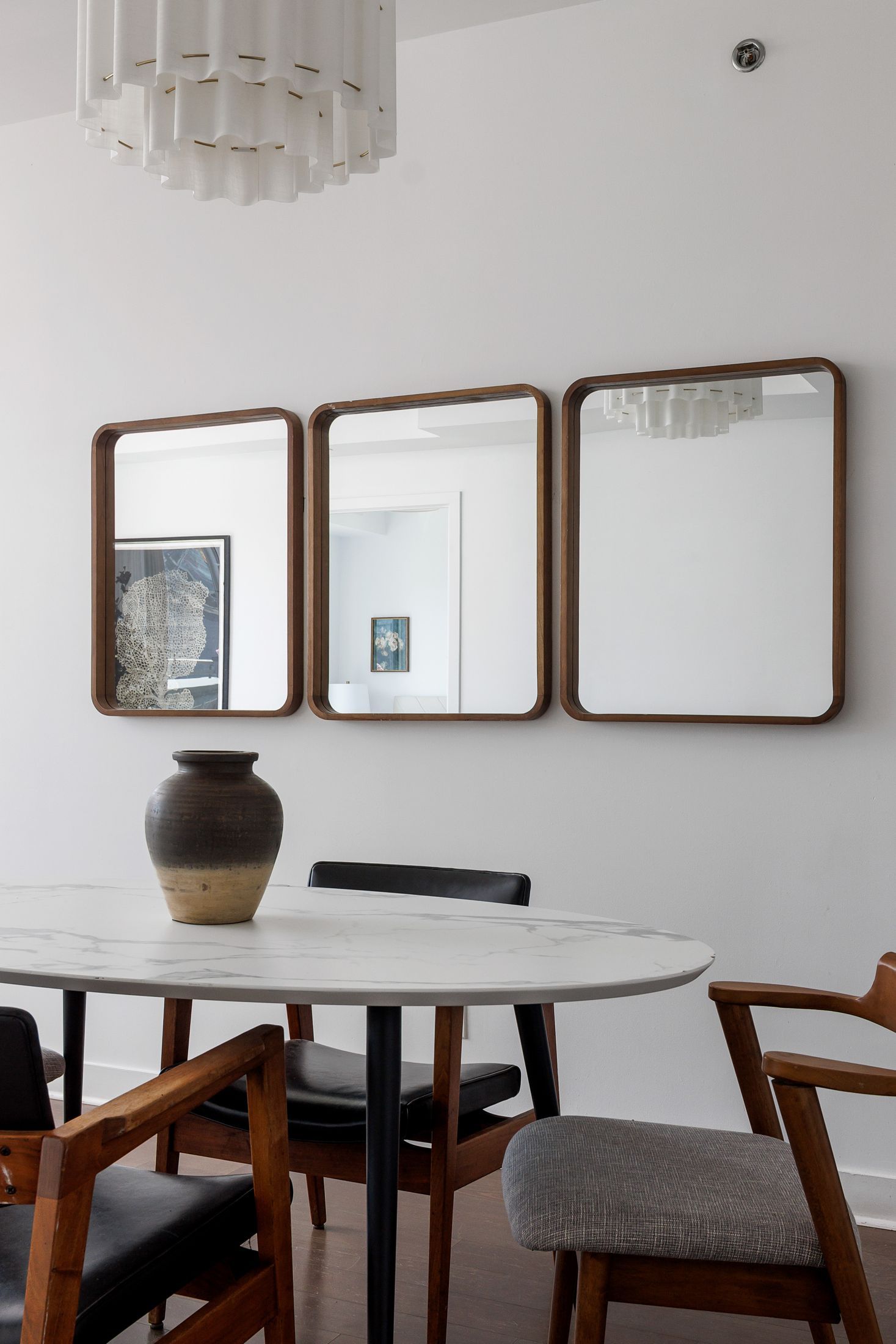 Dining nook with a marble table and grouped mirrors